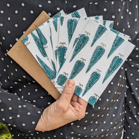A set of handcrafted cards with a turquoise peacock stamp design, accompanied by kraft paper envelopes