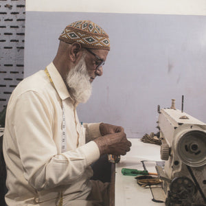 Artisan working on a sewing machine in a workshop setting