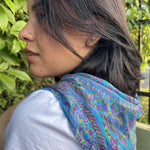 Load image into Gallery viewer, Woman wearing a colorful scarf with a blurred green outdoor background
