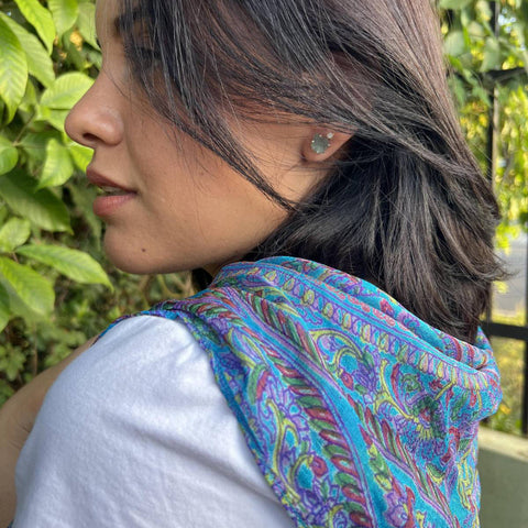 Woman wearing a colorful scarf with a blurred green outdoor background
