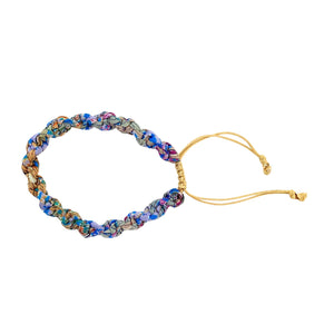 A blue and gold handmade bracelet on a white background