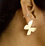 Load image into Gallery viewer, Close-up of a person wearing a  gold toned butterfly-shaped earring.
