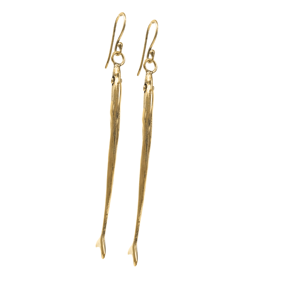 Long, slender gold toned, fish-shaped earrings on a white background