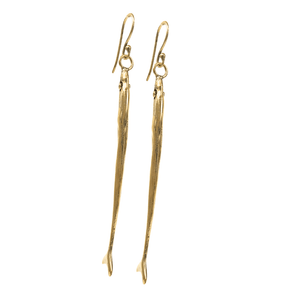 Long, slender gold toned, fish-shaped earrings on a white background