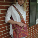Load image into Gallery viewer, Woman with a colorful patterned tote bag on her shoulder against a brick wall
