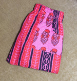 Load image into Gallery viewer, Pink and red patterned fabric on a beige surface
