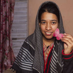 Load image into Gallery viewer, Artisan lady holding a pink butterfly-shaped object indoors
