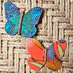 Load image into Gallery viewer, Colorful butterfly-shaped hair clips on a woven surface
