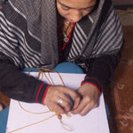 Load image into Gallery viewer, A woman working with thread
