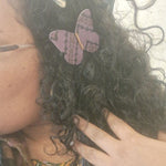 Load image into Gallery viewer, Close-up of a person with curly hair wearing a butterfly hair clip, with another hand touching the hair.
