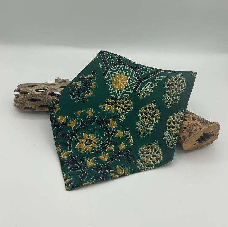 Green patterned bib on a white background with wooden elements.