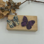 Load image into Gallery viewer, Butterfly-shaped hair clips with floral patterns  on wooden blocks with a white background
