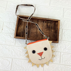 Children's lion-shaped purse with a strap on a white tiled background