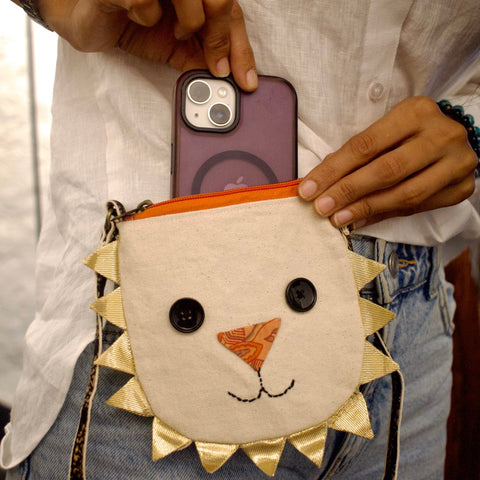 Person holding a phone with a lion-themed pouch