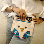 Load image into Gallery viewer, Person holding a small owl-shaped purse with a textured white background
